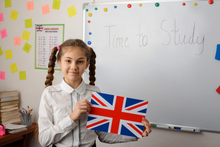 Uczennica z flagą UK w klasie - młodzieżowe kursy angielskiego w Zgorzelcu