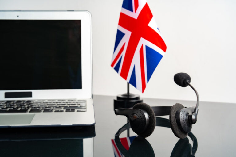 Koncepcja edukacji online z flagą UK obok laptopa osoby uczącej się z Lubina